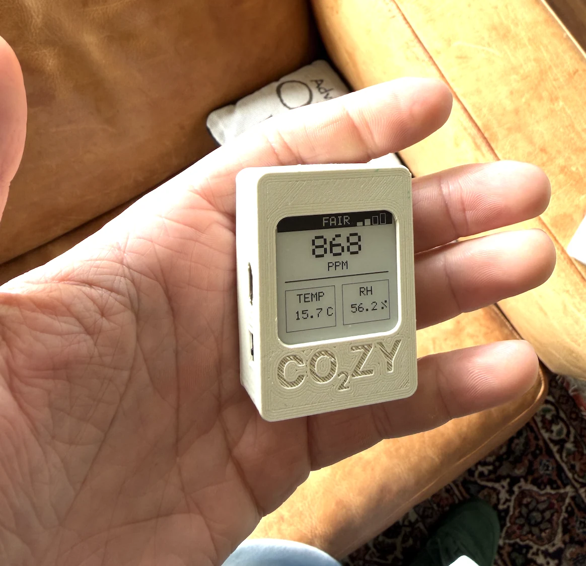 CO₂ZY monitor held in one hand to show its compact size